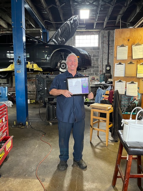 Image of Bob Kunkel smiling and holding designation plaque.